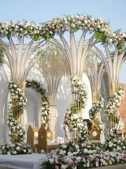 A side view of the modern tree-like mandap, showing the spiraling floral arrangements and the elegant seating for the couple.