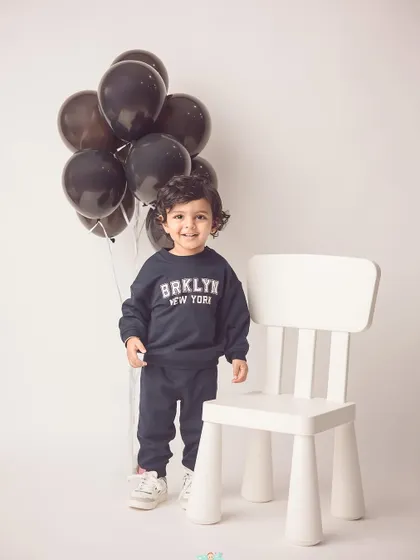 A modern and stylish 18-month shoot. The simple white background and casual outfit create a portrait that feels both candid and polished.
