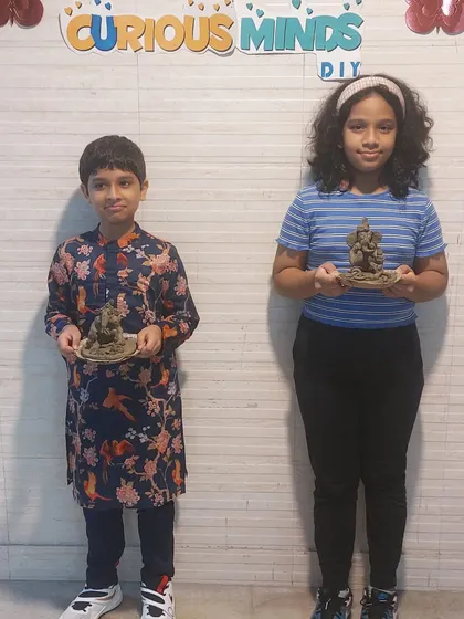 Two siblings proudly display their handmade Ganesha idols. Our workshops are a great activity for families to bond and celebrate their culture and creativity together.