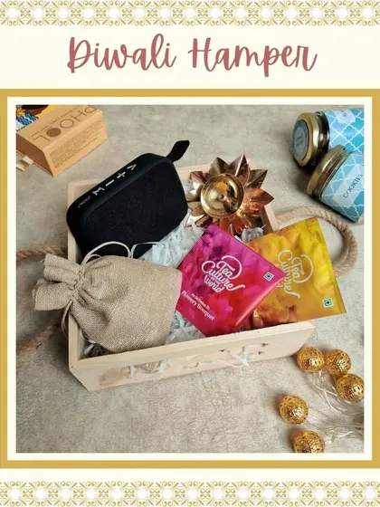 A modern Diwali hamper for the tech-savvy and tea lovers. This wooden tray includes a portable Bluetooth speaker, assorted teas, dry fruits, and a decorative diya.