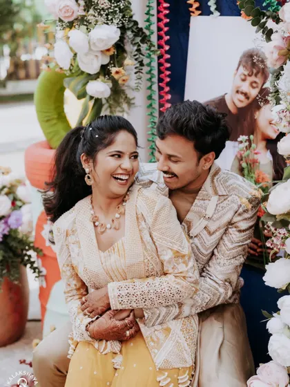 A candid moment of laughter between the couple at their colorful carnival-themed party.