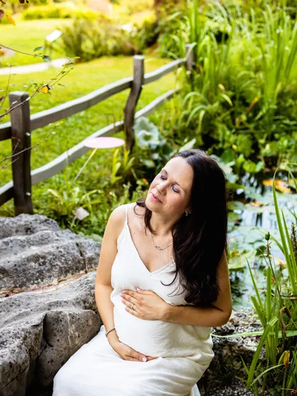 Soaking in the last rays of sun. This serene maternity portrait highlights the beauty of pregnancy against a lush, natural backdrop.