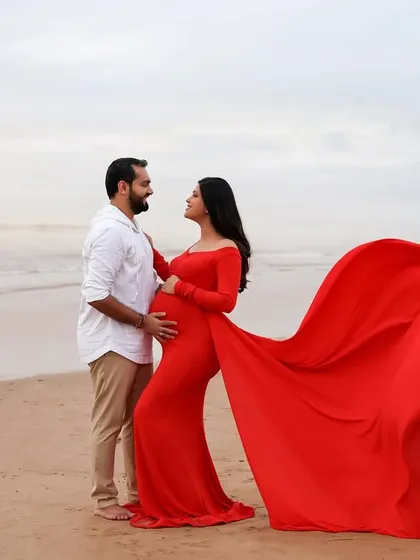 A powerful and romantic portrait of the couple on the beach. The striking red of the gown against the soft colors of the sea and sky creates a visually captivating image.