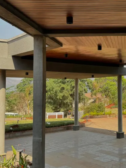 The covered verandah of the 6AM House. The concrete pillars and wooden ceiling create a sheltered outdoor space that feels like a natural extension of the interior living areas.