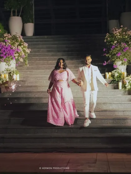 The happy couple makes their entrance, walking down a candlelit staircase.