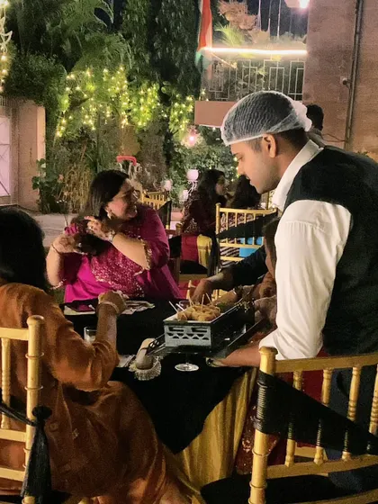 A guest being served at an outdoor event, enjoying the festive atmosphere and our delicious food.