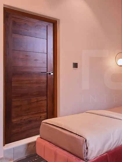 A view of the kids' room showing the beautiful wooden door that contrasts with the soft pink walls.