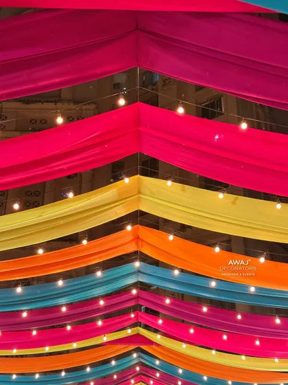 Looking up at the colorful draped ceiling, interspersed with strings of lights for a magical evening glow.