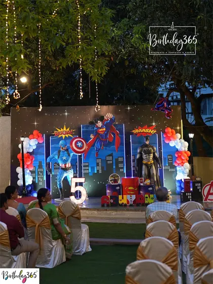 An evening superhero celebration, with the decor lit up against the night sky. The setup included character mascots of Captain America and Batman, creating a truly immersive experience.