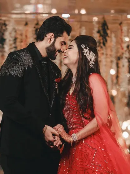 A beautiful, intimate moment between a couple. The groom's custom black suit with silver embroidery perfectly complements the romantic setting.