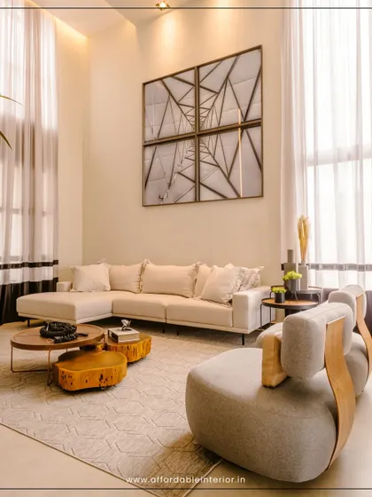 This high-ceiling living room design uses a large sectional sofa and unique, organically shaped coffee tables to create a grand yet inviting space.