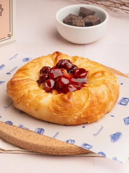 My seasonal fruit danish is a beautiful pastry. A buttery, flaky base is filled with cream and topped with fresh, vibrant cherries.