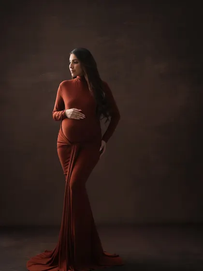 A classic and elegant pose. This three-quarter portrait in a form-fitting brown gown beautifully highlights the curves and glow of pregnancy.
