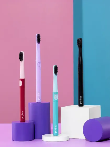 A group shot of Perfora's colorful electric toothbrushes. The use of geometric props and a multi-toned background creates a playful and modern display of the full product range.