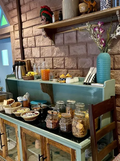 Even a simple breakfast buffet setup can provide decor ideas. I loved the distressed paint finish on this console table, the simple wooden shelving, and the use of glass jars for storage, all practical ideas for a rustic kitchen or dining area.