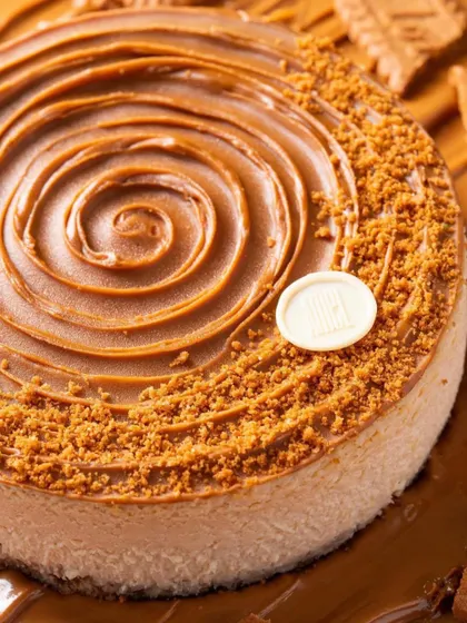 A close-up of a Biscoff cheesecake, highlighting the swirled topping and crumbly texture. Macro shots are essential for making desserts look irresistible.