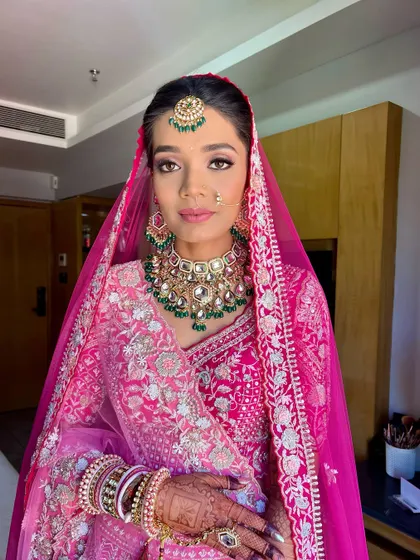 A full view of the final look. The makeup is balanced to complement the heavy jewelry and intricate outfit without overpowering the bride's natural beauty.