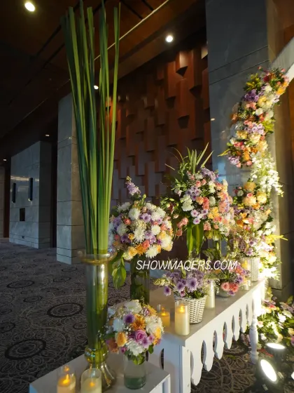 A side view of the entrance decor, showcasing lush floral arrangements and tall glass vases with greenery.