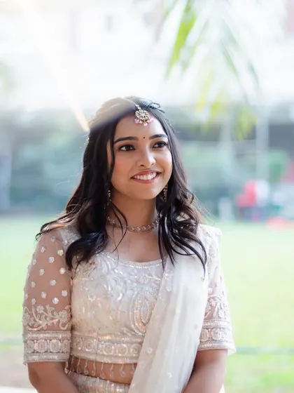 A dreamy, sun-kissed shot. The makeup looks fresh and glowing in the natural light.
