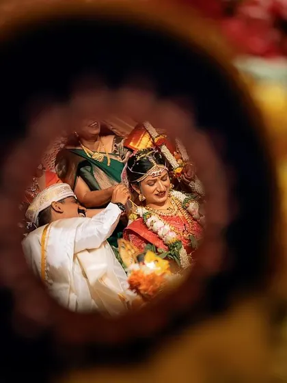 A creative view of the Mangalyam ceremony, framed through a circular object. This artistic composition offers a unique and intimate perspective on a traditional moment.