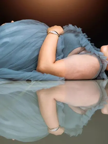 A close-up of the artistic reflection portrait, focusing on the peaceful expression of the mom-to-be. This shot emphasizes the tranquility and inner glow of pregnancy in a fine art style.