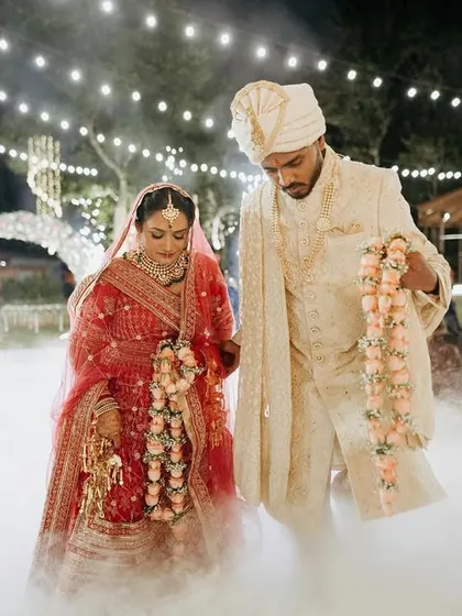 A fairytale-like Varmala ceremony, with the couple surrounded by smoke and lights.