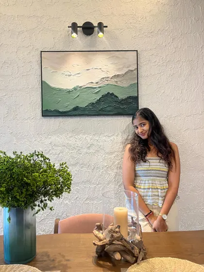 Here I am with a recently installed textured artwork in a client's home. The subtle green hues and mountain-like texture create a serene and natural focal point for their dining space.