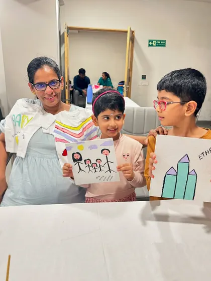 A mother and her children painting together at a baby shower, creating art for the new arrival.