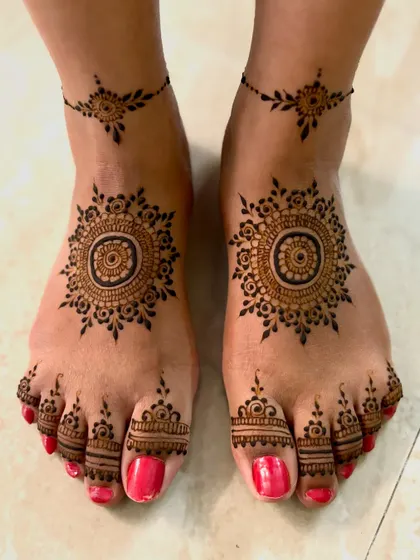 Minimalist feet mehendi with a central mandala and a matching, delicate anklet design.