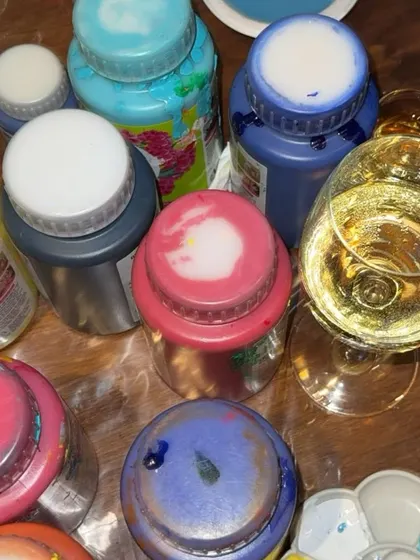 A close-up of the paints and wine that fuel our sip and paint parties. It's all about creating a relaxed and fun atmosphere where you can let your creativity flow.