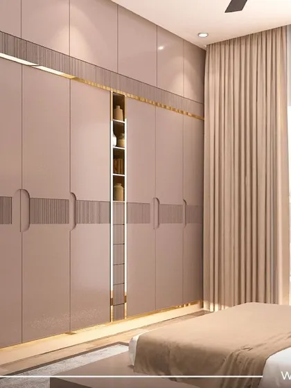 A bedroom from the 'Sobha Daisy' project, featuring a large wardrobe with elegant corner shelves. The design uses a soft, neutral color palette for a calming effect.