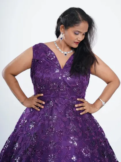 This purple sequin ball gown is ideal for a birthday, anniversary, or wedding party. The V-neckline and full skirt create a classic and flattering silhouette.