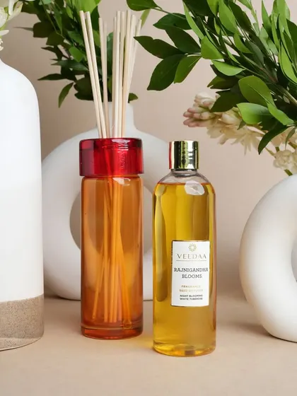 Our Rajnigandha Blooms reed diffuser, shown with its refill bottle. The elegant glass vessel and the rich floral oil are a perfect match for the modern ceramic vases.