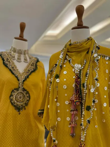 A close-up of the stunning neck embellishments. The use of mirrors, threadwork, and beads creates a rich, multi-dimensional effect.