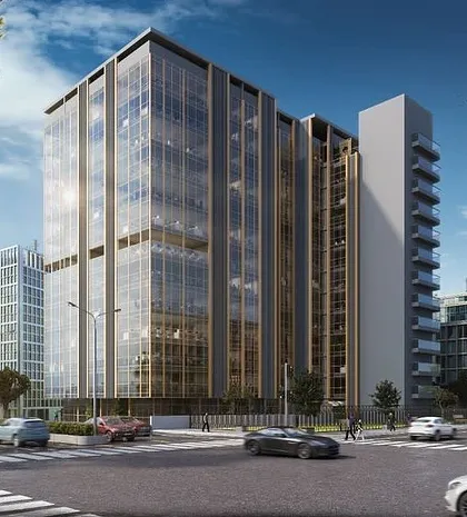 A daytime exterior rendering of a glass-clad commercial office building. The image captures the reflections on the facade and the flow of traffic, creating a realistic depiction of the building in its urban setting.