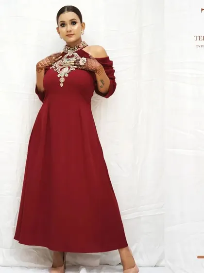 A closer look at the details of our maroon cold-shoulder gown. The hand-embroidered neckpiece is the star of this outfit, designed to make you feel like royalty.