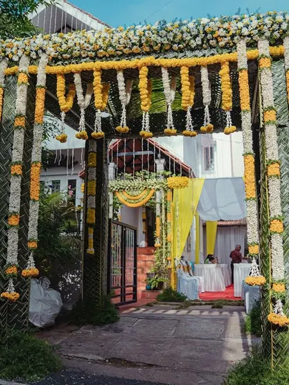 A grand floral arch at the entrance, made with lush garlands of white and yellow marigolds, creates an impressive and traditional welcome for all the guests.