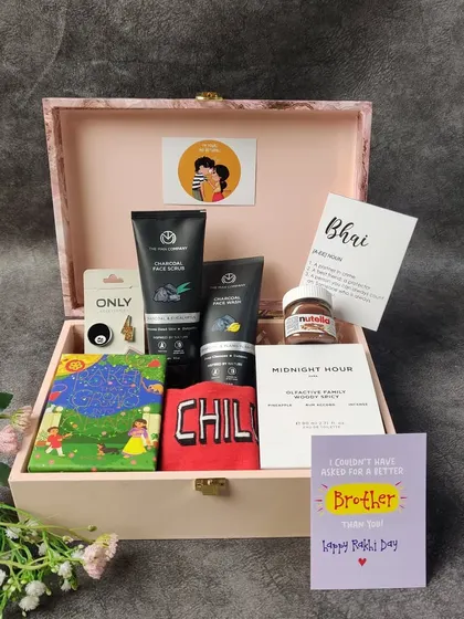 A classic Rakhi gift box for a brother. This hamper features men's grooming essentials, a fun "CHILL" t-shirt, a little jar of Nutella, and a heartfelt card, all packed in a reusable wooden box.