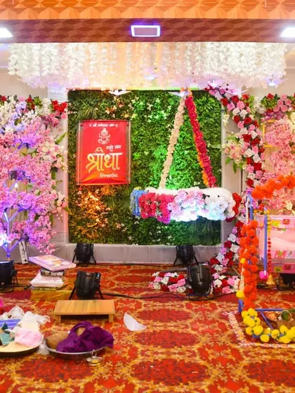 Another angle of the naming ceremony decor, showing the full floral and lighting arrangement.