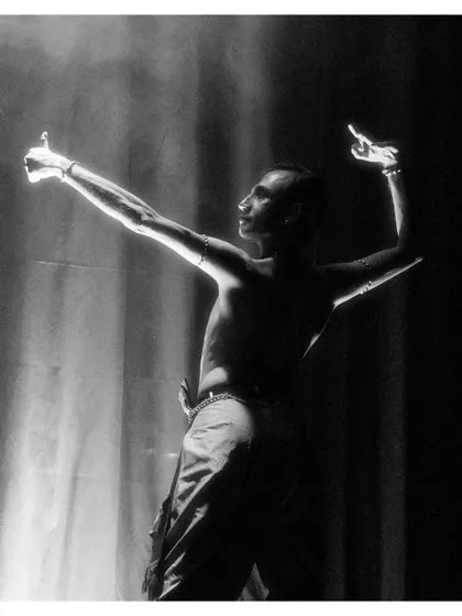 A dramatic black and white silhouette from "Tyāgarāja Hṛt Sādana." The lighting creates a powerful visual, emphasizing the form and posture of the dancers.