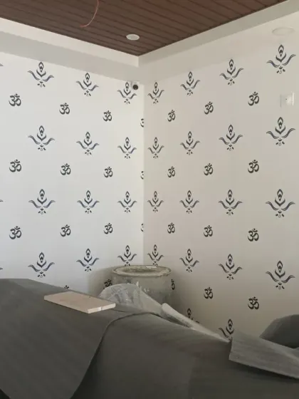A simple and elegant wallpaper featuring the 'Om' symbol and other traditional motifs, perfect for a yoga studio or meditation space.