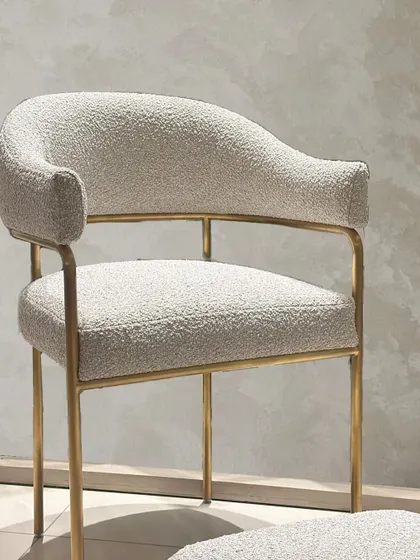 The full view of the bouclé chair and footrest, showcasing its elegant proportions and the balance of modern sophistication and functional design.