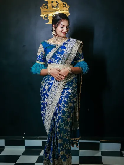 A stunning blue Banarasi saree with a modern twist. The feather-detailed blouse adds a touch of contemporary glamour to the traditional fabric.