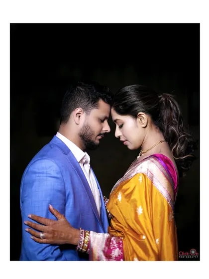 An intimate and artistic couple portrait from an engagement shoot, with a dark background that emphasizes their connection.