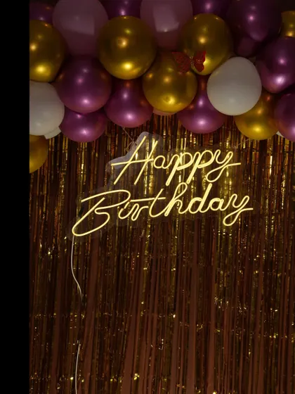 Another close-up of a 'Happy Birthday' neon sign from a butterfly-themed party.