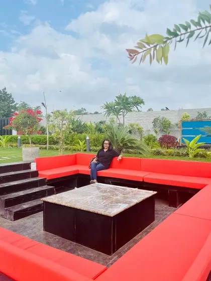If paradise exists on earth, it can be found in a garden. This Delhi farmhouse features a unique sunken seating area with bold red cushions, creating a perfect spot for gathering and entertaining outdoors.