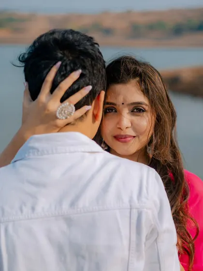 A beautiful over-the-shoulder portrait with the lake and hills behind. This shot combines a classic romantic pose with a stunning natural landscape, perfect for a destination pre-wedding shoot.
