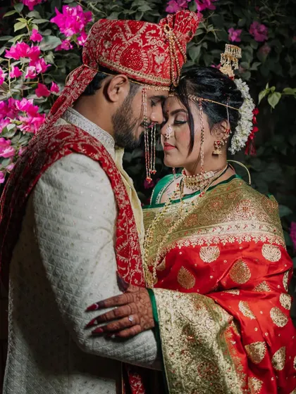 A classic and romantic portrait of the couple against a backdrop of vibrant bougainvillea. The rich colors of their outfits and the flowers create a stunning visual.