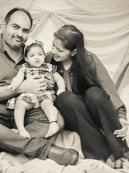 A classic family portrait in a sepia tone, taken in our studio with a soft, draped background.
