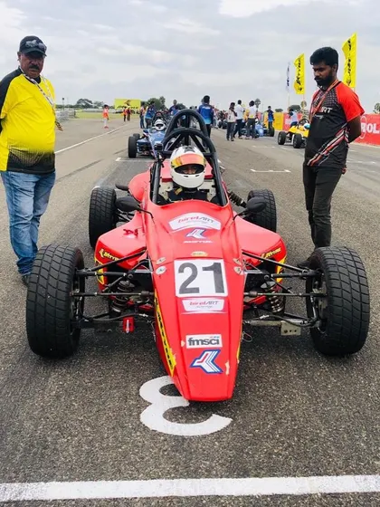 Front view of car 21 on the grid, ready for the race. The driver is focused, and the team is in position.